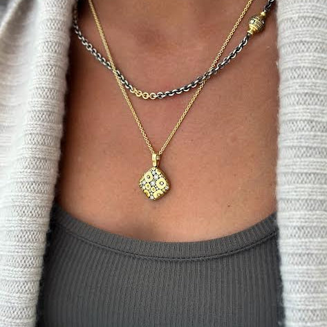 Woman in gray wearing two necklaces