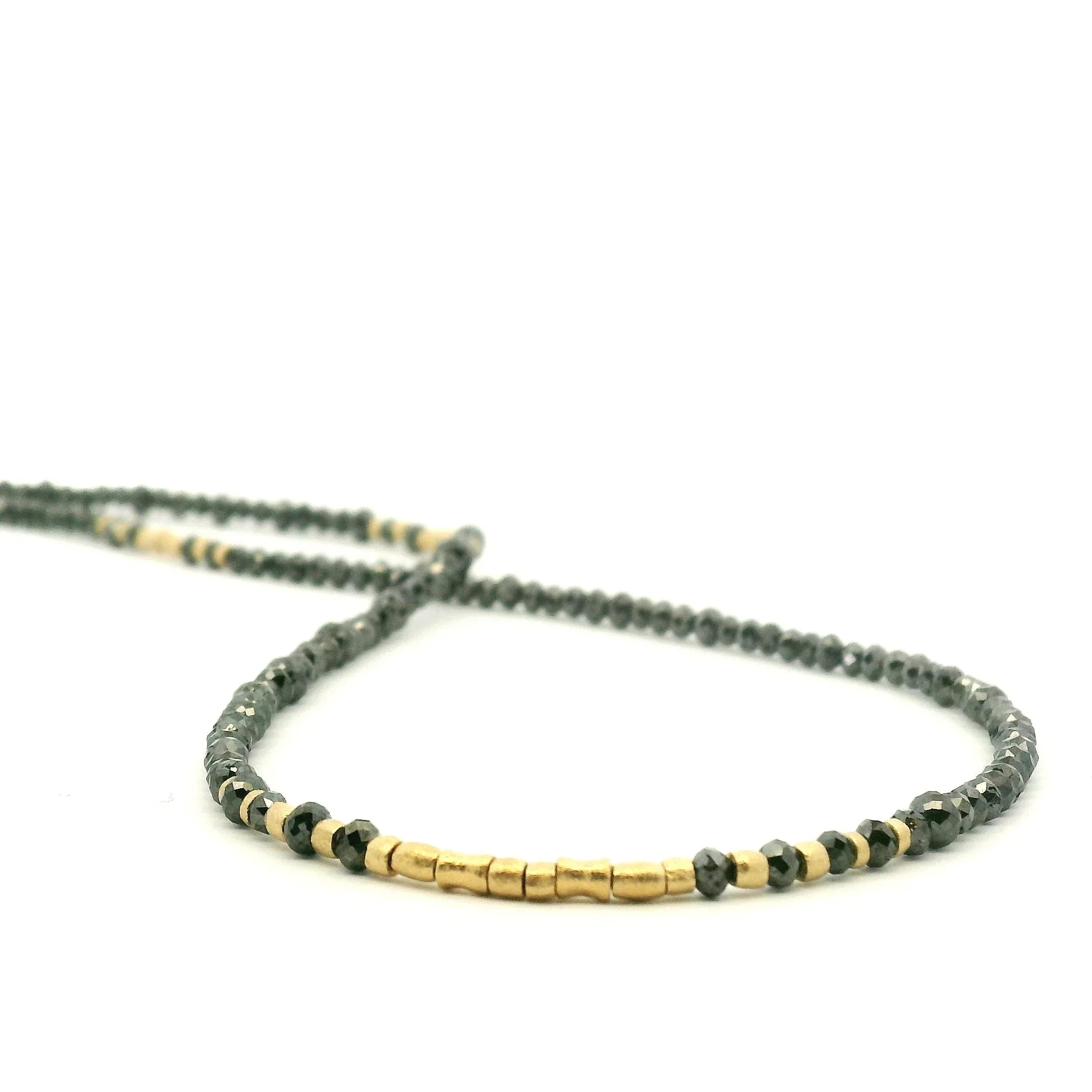 Necklace with black and gold beads on a white background