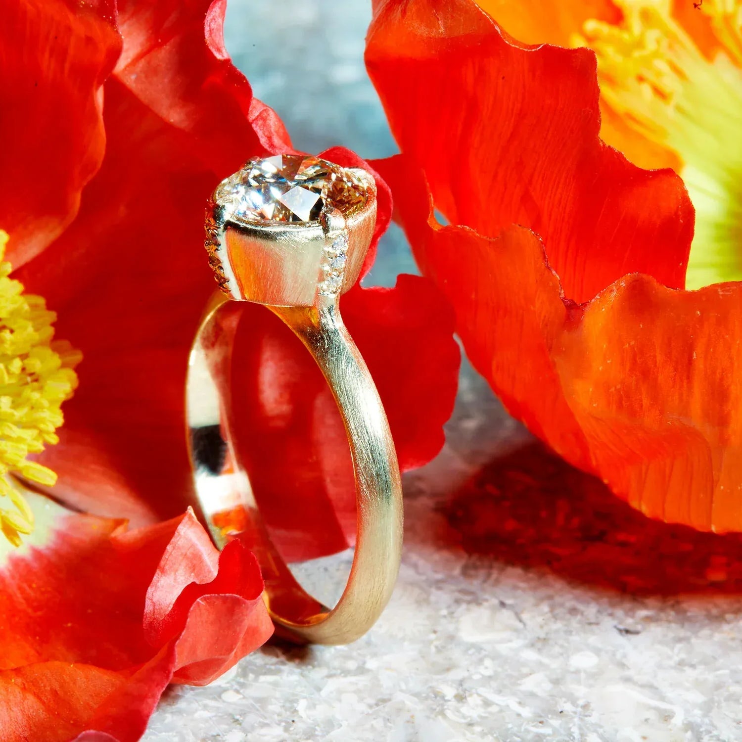 Gold ring with a diamond on red flowers