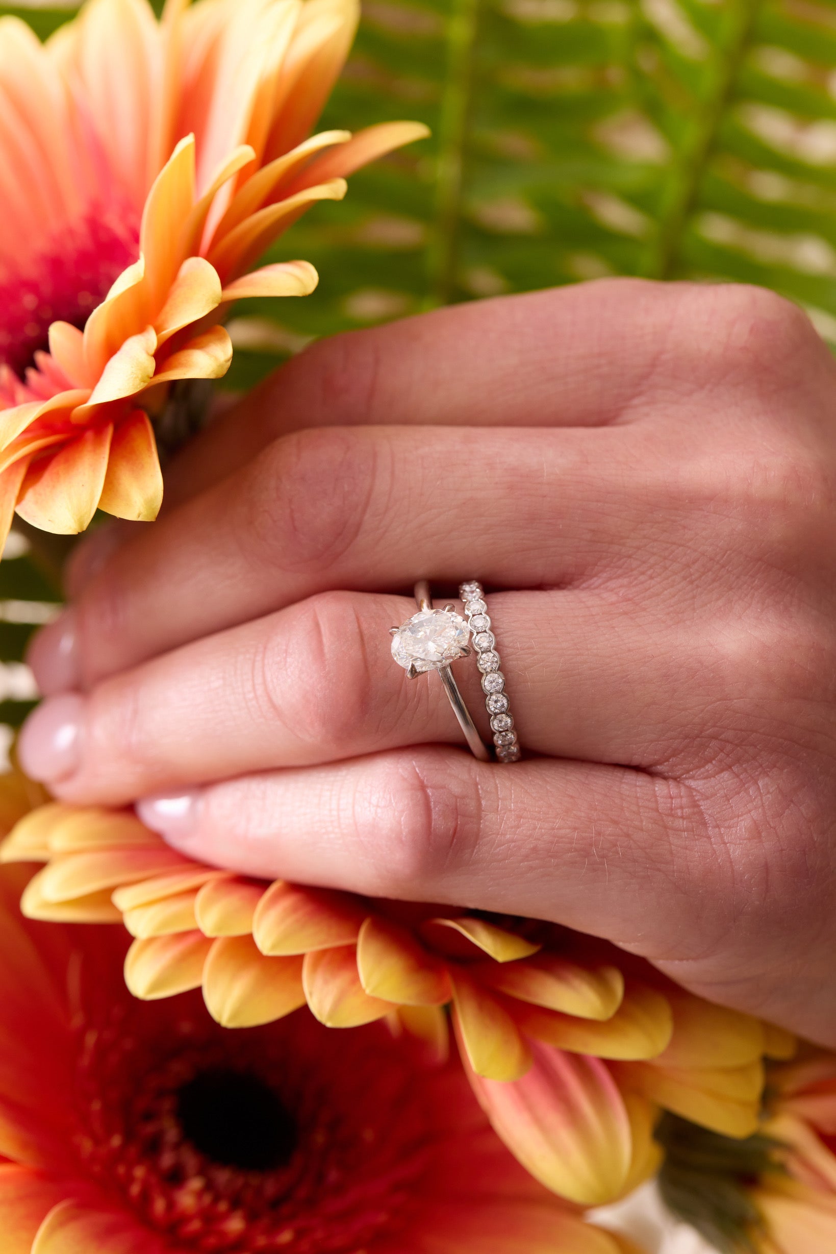 Person in a sweater sitting in an Adirondack chair drinking coffee with a beautiful silver colored ring on