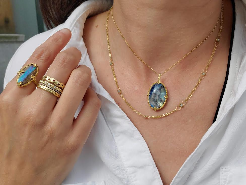 Woman in white shirt wearing rings and pendants