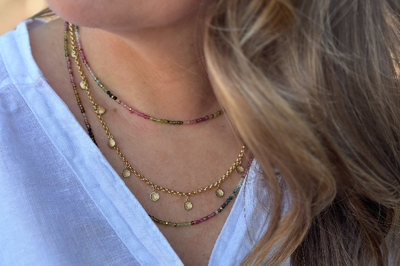 Blonde woman with a white button down shirt and 3 necklaces