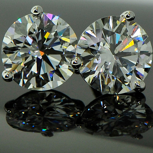 Two diamond studs displayed on glass
