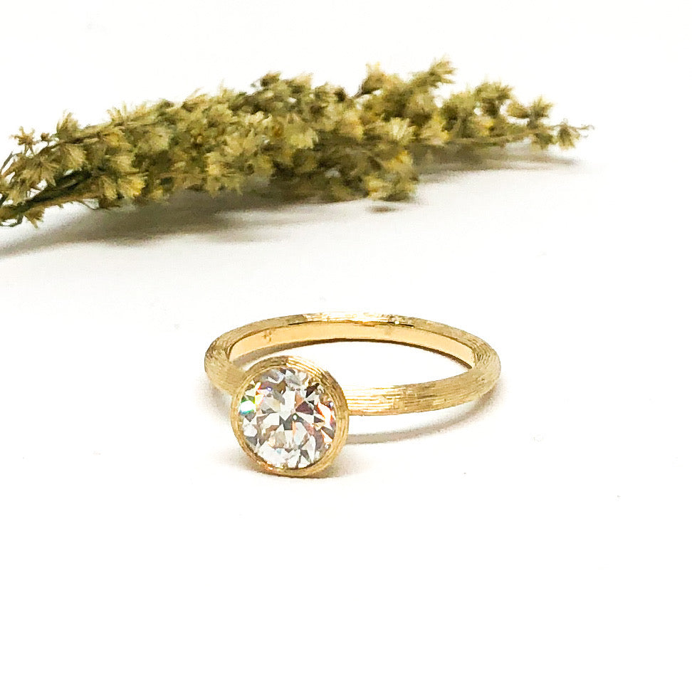 Golden ring with a diamond and a green plant