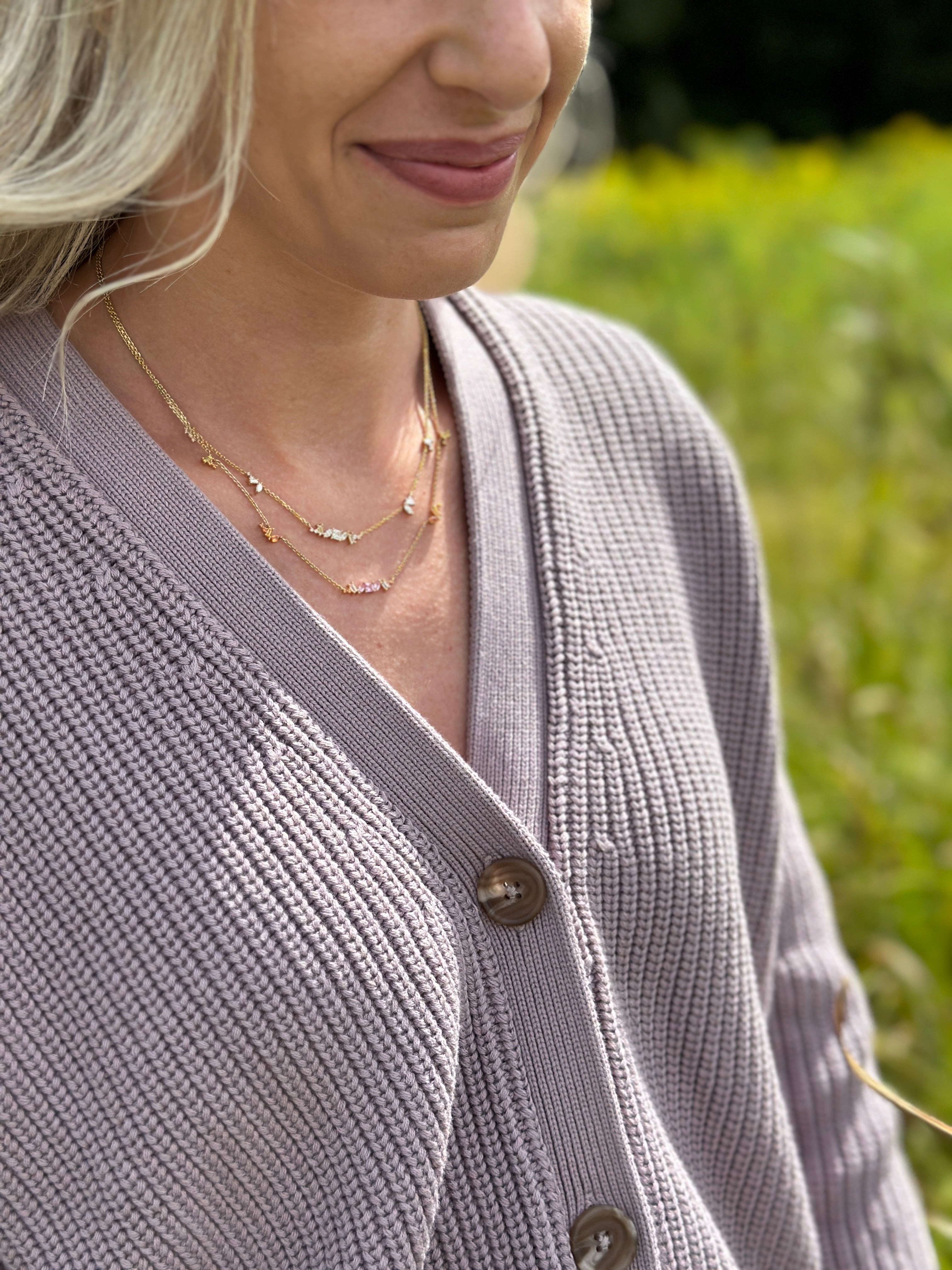 Blond woman in a lavender top wearing Melissa Kaye necklaces