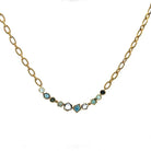 Gold necklace with gemstones on a white background