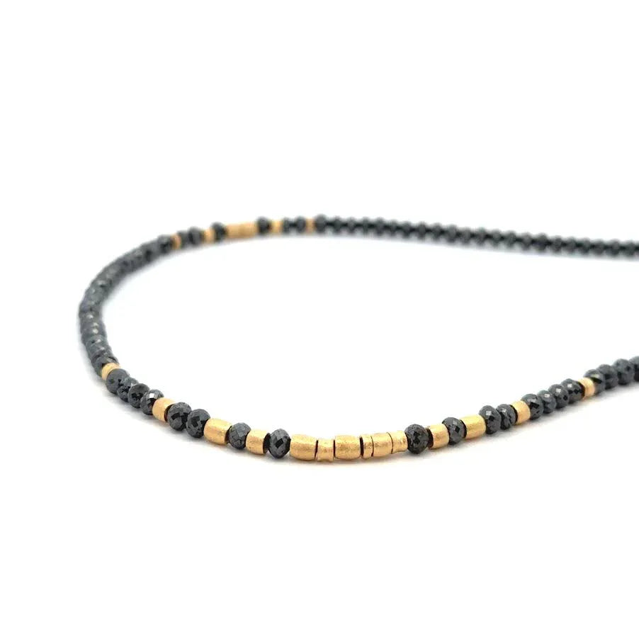 Necklace with black and gold beads on a white background