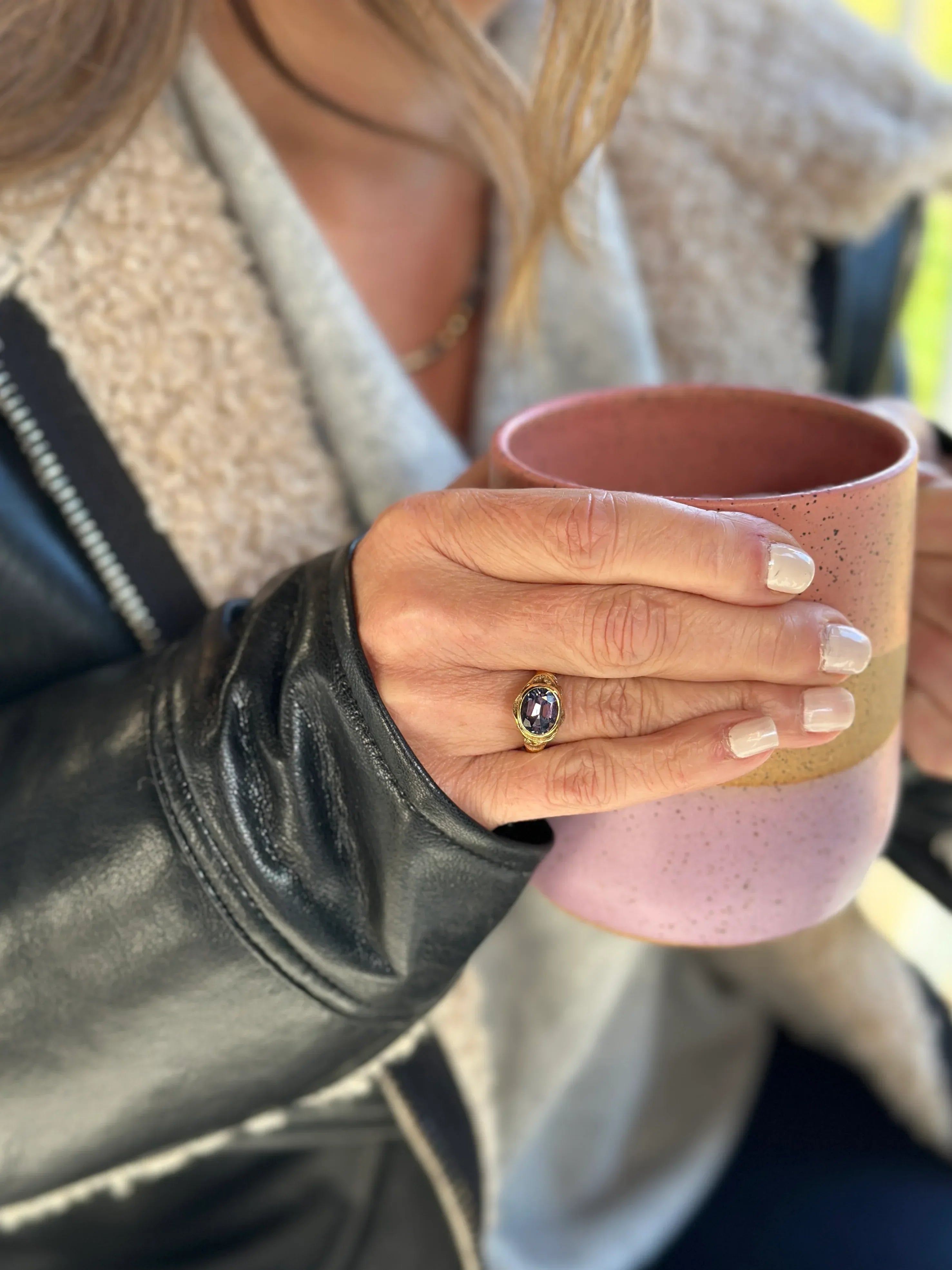 Person holding a pink mug with a blurred background