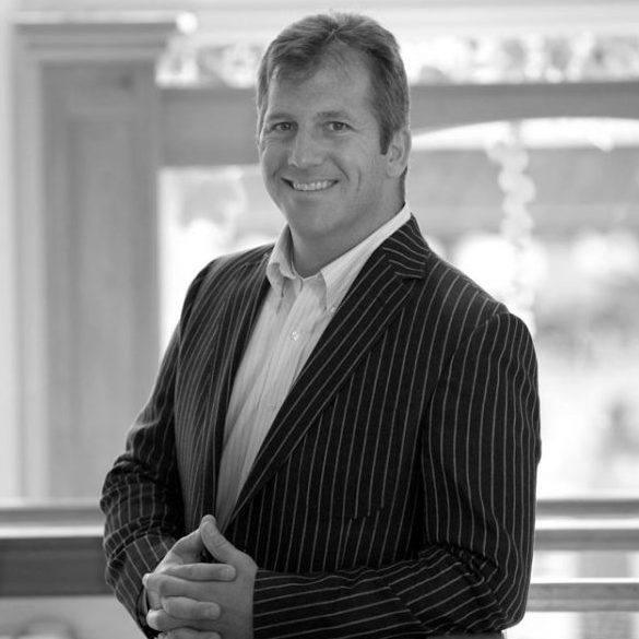 Black and white photo of a man in a suit with a blurred background