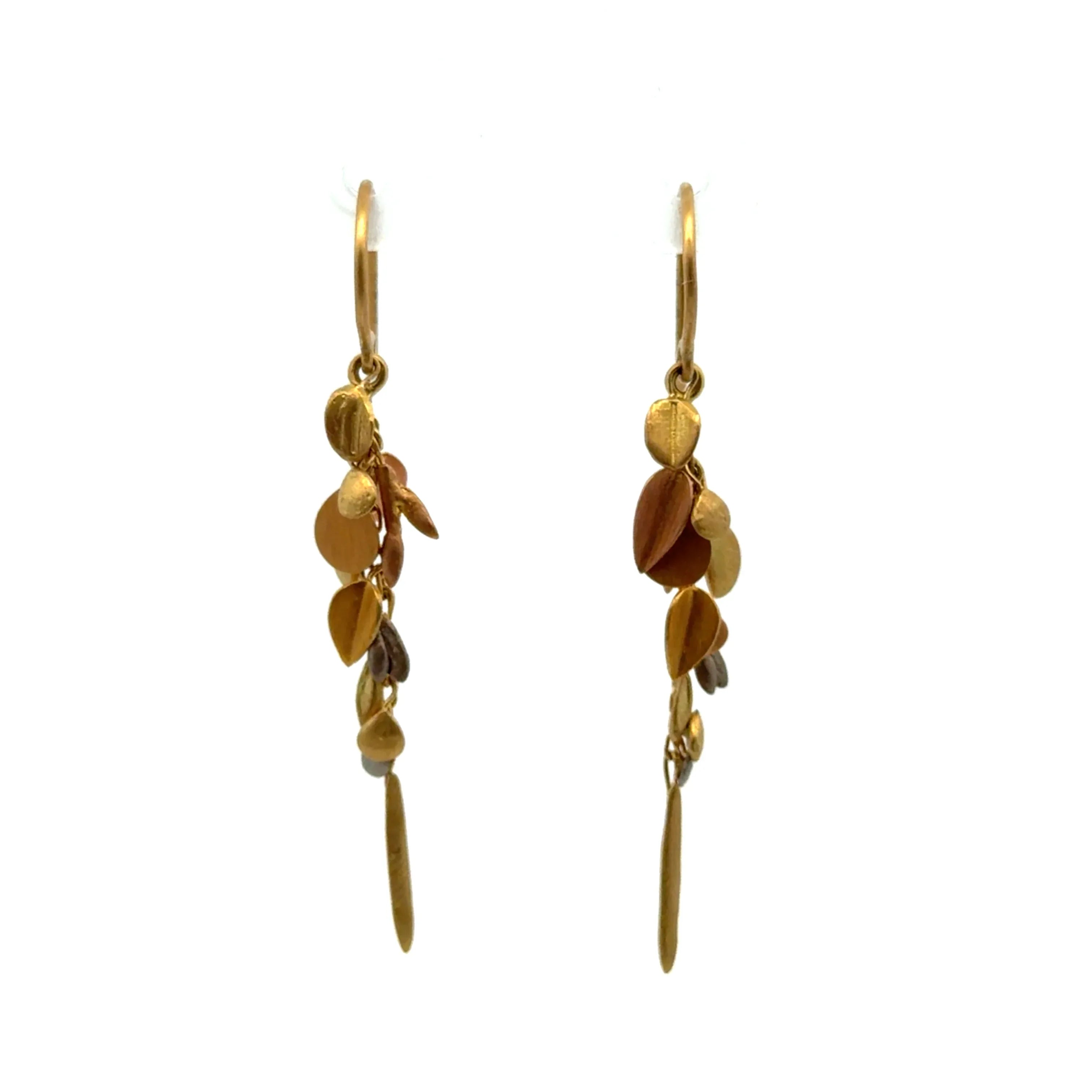 Gold and bronze leaf-shaped earrings on a white background