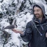 Person holding a bird in a snowy landscape - Orin Pacht - Von Bargen's Jeweler