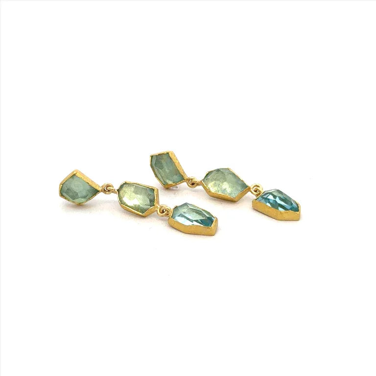 Gold earrings with green gemstones on a white background