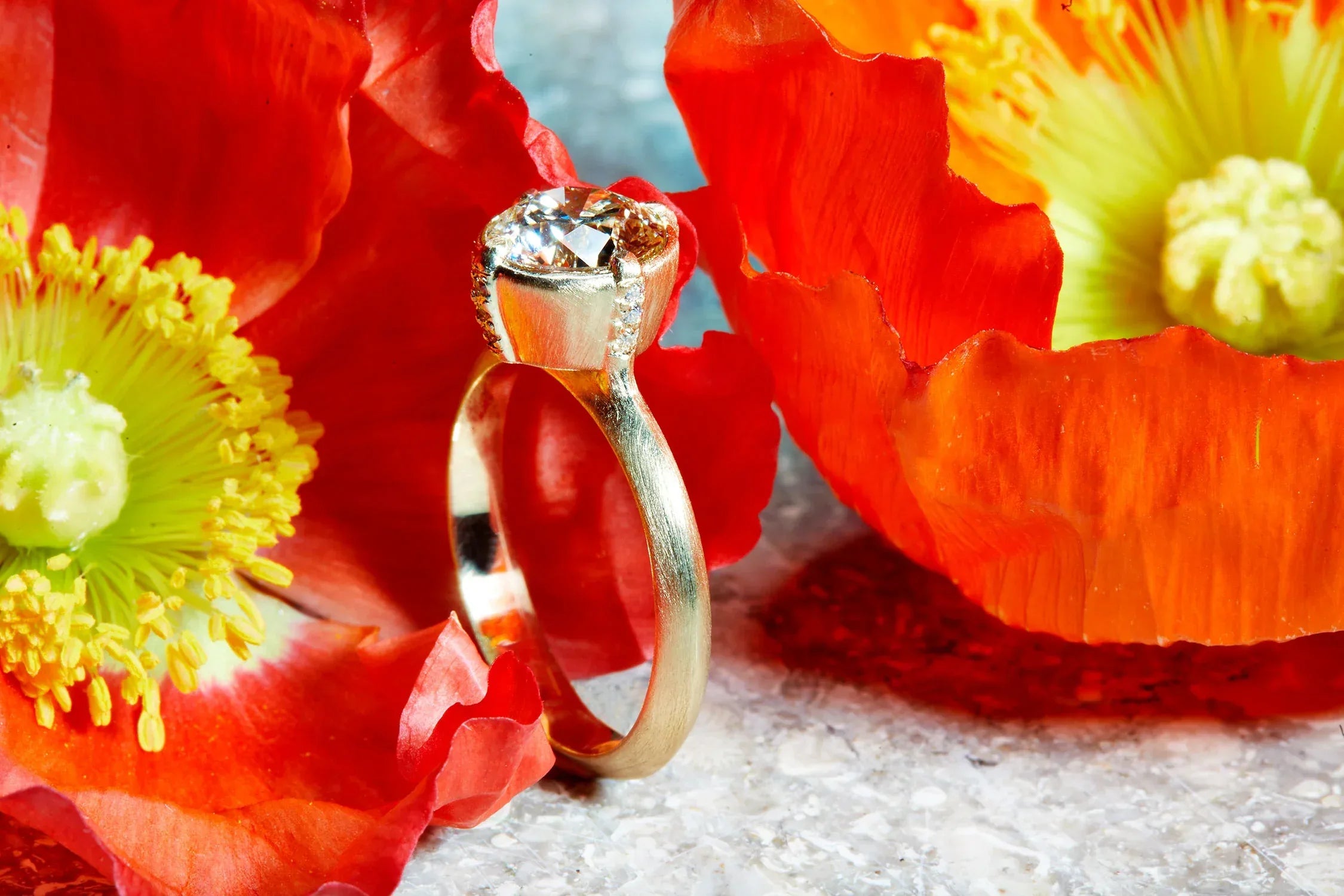 Gold ring with a diamond on red flowers