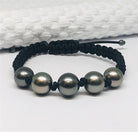 Black cord bracelet with five gray beads on a white background